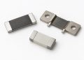 Three unbranded low-ohmic current-sense resistors and shunts arranged naturally on a white background