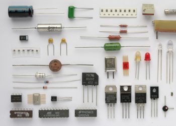 Real resistors capacitors diodes transistors integrated circuits and a relay arranged on a white background