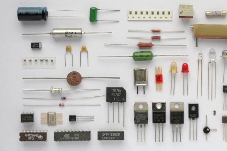 Real resistors capacitors diodes transistors integrated circuits and a relay arranged on a white background