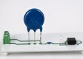Three-lead thermally protected MOV connected to a status LED and optocoupler test board